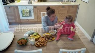 家庭，食物，孩子，营养和亲子观念-快乐的年轻母亲和婴儿一起吃早餐